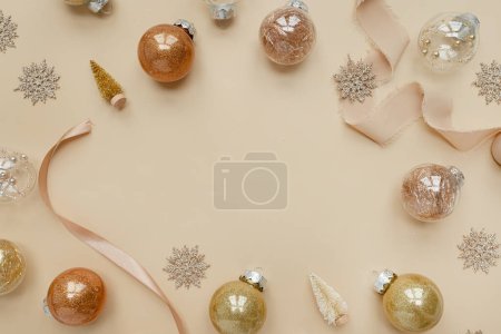 Photo for Golden confetti and Christmas toy balls on neutral beige background. Flat lay, top view Christmas holidays background with copy space - Royalty Free Image
