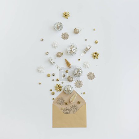 Foto de Sobre de papel artesanal con decoraciones de árboles de Navidad, bolas, estrellas, cintas sobre fondo blanco - Imagen libre de derechos