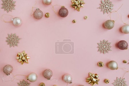 Foto de Elegante composición navideña. Montura simulada con espacio de copia en blanco hecha de bolas de Navidad coloridas, bolas, estrellas sobre fondo rosa. Plano laico, concepto de vacaciones vista superior - Imagen libre de derechos