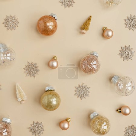 Foto de Confiti dorado y pelotas de juguete navideñas sobre fondo beige neutro. Piso laico, vista superior Navidad vacaciones fondo - Imagen libre de derechos