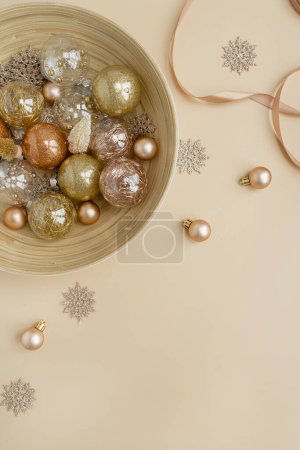 Téléchargez les photos : Confettis dorés et boules de Noël sur fond beige neutre. Flat lay, vue sur le dessus Noël vacances fond avec espace de copie - en image libre de droit