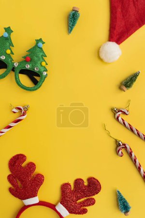 Téléchargez les photos : Cadre de nouvel an drôle, accessoires de Noël pour la fête des vacances d'hiver sur fond jaune - en image libre de droit