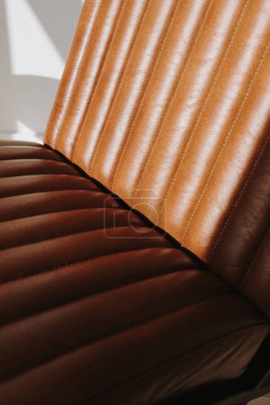 Photo for Aesthetic modern interior detail. Orange colored leather armchair with warm sunlight shadows. Interior object furniture - Royalty Free Image