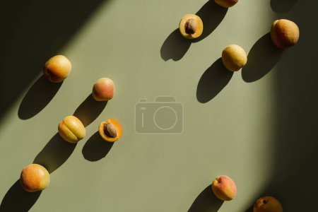 Photo for Peaches on light green background with sunlight shadows - Royalty Free Image