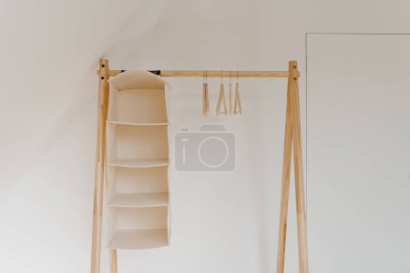 Téléchargez les photos : Cintres vides sur le cintre au sol au-dessus du mur blanc. Concept intérieur minimaliste avec garde-robe. Boutique de mode en ligne, fond de boutique en ligne - en image libre de droit