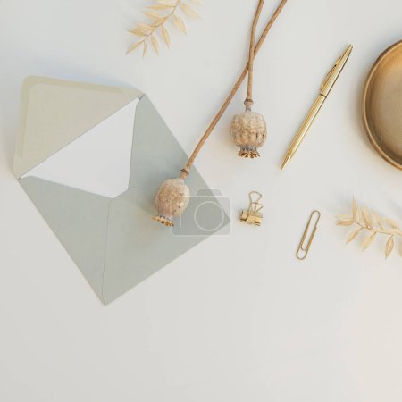 Photo for Wedding celebration invitation. Craft envelope, paper, poppy stems, stationery on white background. Flat lay, top view aesthetic anniversary event composition - Royalty Free Image