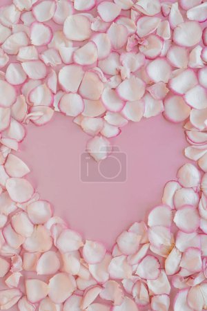 Photo for Valentine's Day concept. Heart made of pink rose flower petals on pastel pink background. Flat lay, top view - Royalty Free Image