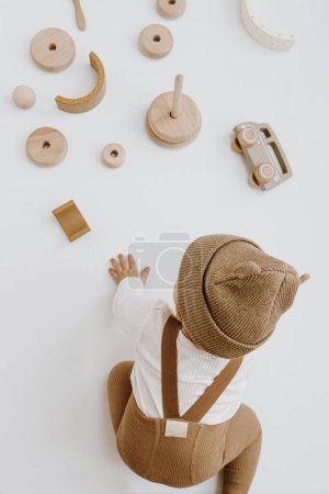 Photo for Top view of cute one year old baby plays with toys. Baby fashion concept. Neutral colors - Royalty Free Image