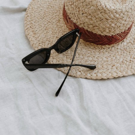 Foto de Composición estética de moda con ropa y accesorios femeninos. Sombrero de paja, gafas de sol en vestido de lino beige pastel - Imagen libre de derechos