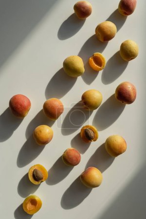 Photo for Fruit pattern of fresh peaches with sunlight shadows on neutral beige background - Royalty Free Image