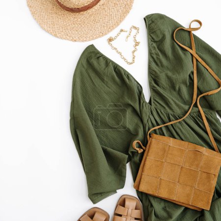 Photo for Aesthetic fashion composition with female clothes and accessories. Green evening dress, straw hat, leather sandals, purse, suede bag, necklace. Flat lay, top view. - Royalty Free Image