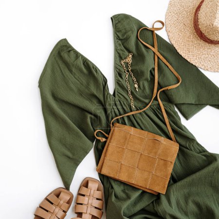 Photo for Flatlay of elegant stylish women's clothes and accessories. Aesthetic luxury fashion composition. Green evening dress, straw hat, leather sandals, purse, bag, necklace. Flat lay, top view copyspace - Royalty Free Image
