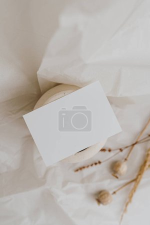 Photo for Blank paper card sheet with empty free copy space for mock up. Dried grass, poppy stems and clay pot. Aesthetic neutral beige colour. Flat lay, top view - Royalty Free Image