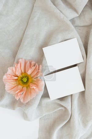 Foto de Flatlay hojas de papel en blanco, flor de amapola rosa en manta arrugada. Marca de negocios, plantilla de redes sociales. Piso tendido, vista superior - Imagen libre de derechos