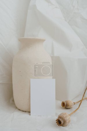 Photo for Card sheets with blank empty free copy space for mock up, dried poppies, beige clay pot on white wrinkled cloth. Bright elegant aesthetic invitation template for business branding - Royalty Free Image