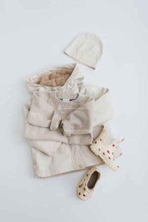 Foto de Jersey para niños, impermeable, botas de lluvia de goma, sombrero sobre fondo blanco. Traje de moda de bebé - Imagen libre de derechos