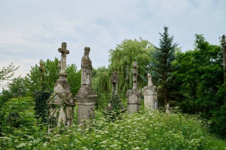 Photo for Ancient orthodox ukrainian graveyard with stone statues of saint and crosses, close-up - Royalty Free Image
