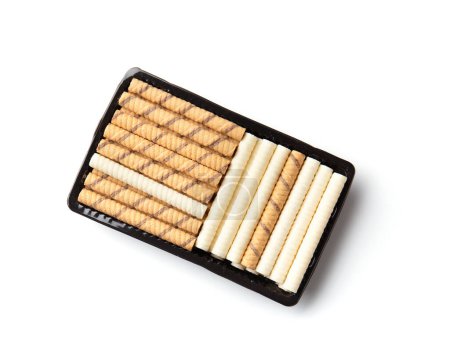 Téléchargez les photos : Chocolate and milk crispy wafer rolls in a package. Wafer rolls on a white background. Crispy dessert isolated. Chocolate tubes top view. - en image libre de droit