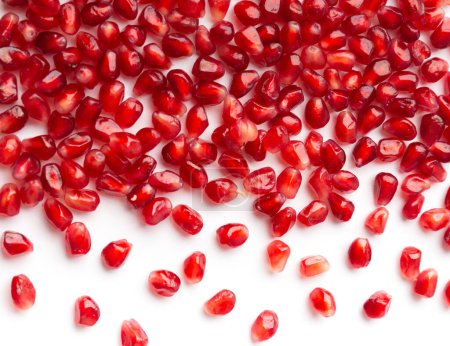 Téléchargez les photos : Red grains of a ripe pomegranate are neatly laid out on a white background top view. Pomegranate grains on isolated. Background of pomegranate seeds. - en image libre de droit