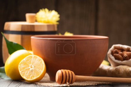 Photo for Wooden barrel for honey, clay bowl with honey, dipper, lemon, yellow flowers on a wooden background. Still life of useful products. Composition of honey in different dishes, lemon, flowers close-up. - Royalty Free Image
