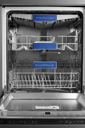 Photo for Modern built-in stainless steel dishwasher with open door in the kitchen front view. Household kitchen appliances. Dishwashing equipment. - Royalty Free Image