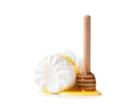 Téléchargez les photos : Verser le miel sur les guimauves en isolement. Guimauves blanches soufflées versées avec du miel, des gouttes de miel et une cuillère en bois pour le miel sur fond blanc gros plan. - en image libre de droit