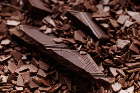 Téléchargez les photos : Des morceaux de chocolat noir cassé dans des pépites de chocolat en gros plan. Fond chocolat. - en image libre de droit