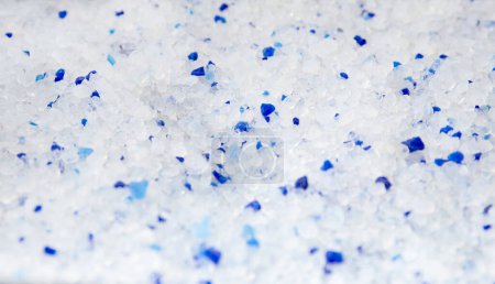 Foto de Silica gel white with blue crystals cat litter close-up. Abstract background of pure silica gel crystals. - Imagen libre de derechos