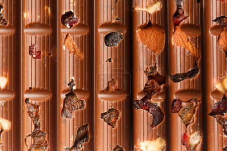 Photo for Chocolate background. Milk chocolate with almonds, raisins, dry berries close-up as a background. - Royalty Free Image