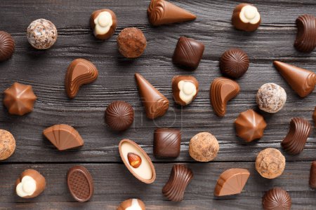 Photo for Various dark and milk chocolate candies, chocolate truffles on a dark wooden texture background top view. - Royalty Free Image