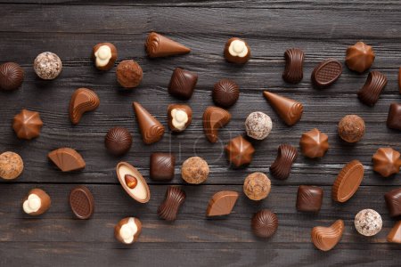 Photo for Various dark and milk chocolate candies, chocolate truffles on a dark wooden texture background top view. - Royalty Free Image