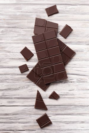 Photo for Whole bar of dark chocolate and broken chocolate on gray wooden background, top view, chocolate background. - Royalty Free Image