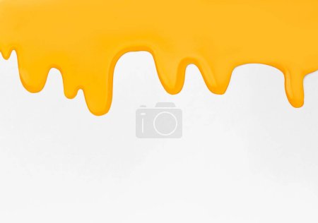 Foto de Flowing drops of honey on a yellow background with space for text. Abstraction from honey drips. Fluid yellow sludge. - Imagen libre de derechos
