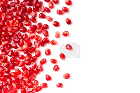 Photo for Red grains of a ripe pomegranate on a white background top view with place for text. Pomegranate grains on isolated flat lay. Background of pomegranate seeds. - Royalty Free Image