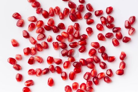 Photo for Large ripe pomegranate seeds on a white background, top view, flat lay, background of pomegranate seeds. - Royalty Free Image