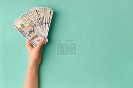 Photo for A lot of bills of 100 dollars in hands are folded in a fan on a green background top view with space for text. Currency, banknotes in female hands. The concept of success, business, wealth. - Royalty Free Image