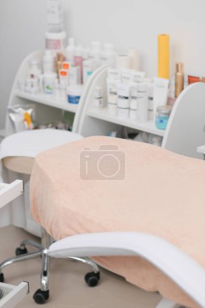 Photo for Modern beautician office with couch, face care cosmetics and body care products. The interior of the massage room, medical office. - Royalty Free Image