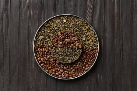 Photo for Green dry tea and coffee beans in two round plates of different sizes one on top of the other on a dark wooden background top view copy space. Conceptual composition of green tea and coffee beans. - Royalty Free Image