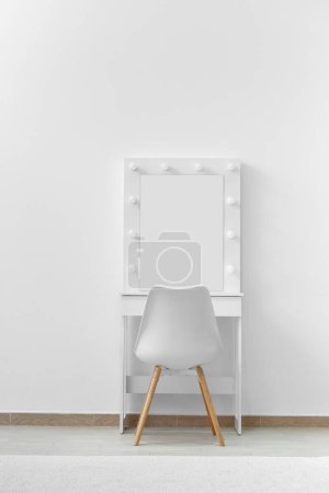 Photo for White dressing table for make-up with a large mirror and lamps, a white chair against the background of the wall. Makeup artist workplace, modern dressing room. - Royalty Free Image
