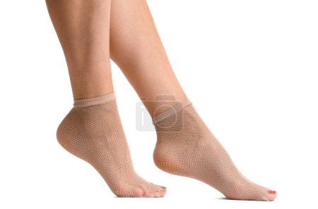 Photo for Female legs in beige short mesh socks, isolated on white background, fishnet socks, close-up. - Royalty Free Image