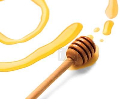 Foto de Olla de madera con miel aislada sobre fondo blanco. Miel floral orgánica dorada natural. Ilustración abstracta de miel y cazo. Gotas de miel y cuchara de madera. - Imagen libre de derechos