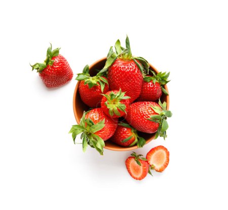 Téléchargez les photos : Grandes fraises biologiques juteuses mûres dans un bol en céramique d'argile isolé sur un fond blanc vue de dessus. - en image libre de droit