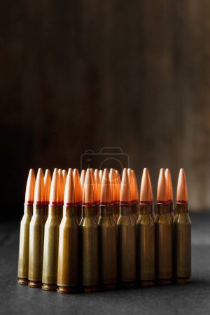 Photo for Ammunition, bullets, live ammunition for firearms on a black wooden background, close-up - Royalty Free Image