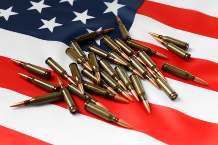 Téléchargez les photos : Des balles pour des armes à feu, des cartouches de l'armée de combat sur le drapeau américain. Le concept de prêt-bail, la fourniture d'armes, le soutien, la vente d'armes. - en image libre de droit