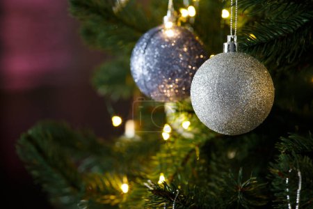 Foto de Las ramas del árbol de Navidad están decoradas con bolas de Navidad y luces sobre un fondo oscuro, espacio para copiar. Postal, plantilla, banner para las vacaciones de invierno. - Imagen libre de derechos