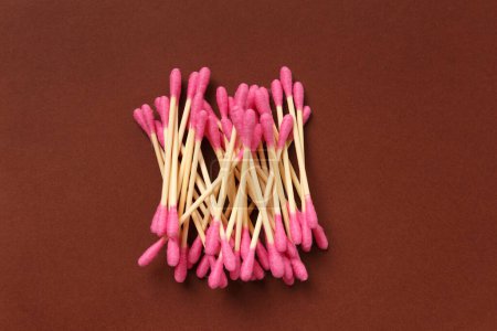 Photo for Bamboo cotton swabs buds sticks on a brown background, top view. Eco-friendly items for hygiene, makeup, medicine. - Royalty Free Image