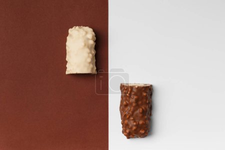 Photo for White and milk chocolate on contrasting backgrounds. Two halves of a chocolate bar with crispy wafers. Conceptual representation of two opposites in the theme of chocolate. - Royalty Free Image