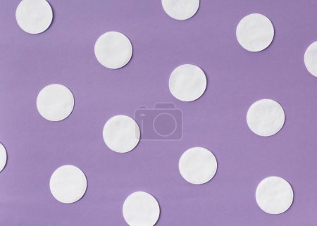 Téléchargez les photos : Tampons de coton sur fond lilas. Le concept de nettoyage, hygiène, médecine, soin de la peau, maquillage, matériaux respectueux de l'environnement - en image libre de droit