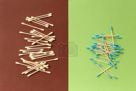 Foto de Bambú algodón hisopos cogollos palos sobre un fondo marrón y verde, vista superior. Artículos ecológicos para la higiene, maquillaje, medicina. - Imagen libre de derechos