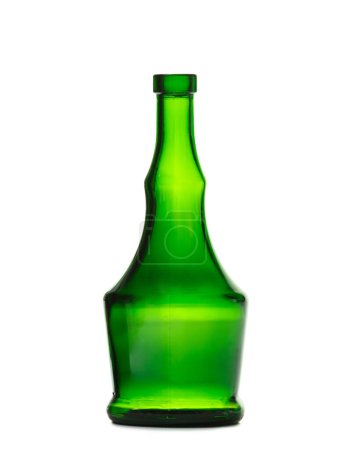 Foto de Una botella vacía para bebidas alcohólicas hechas de vidrio verde oscuro de una hermosa forma inusual, aisladas sobre un fondo blanco. Botella para coñac, whisky, brandy. - Imagen libre de derechos